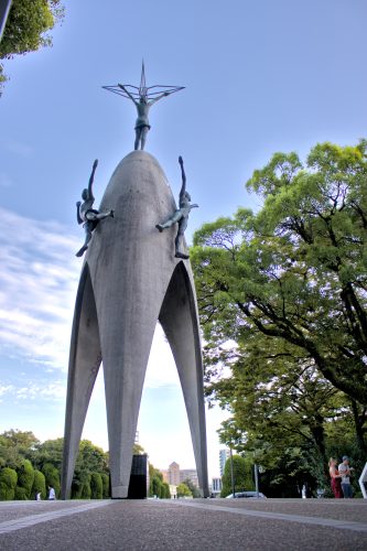 A domed concrete tower with three bronze statues of children on it