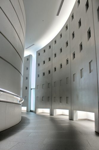 A concrete hallway descends and circles to the left
