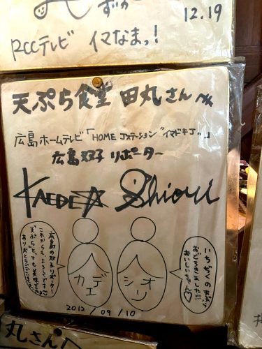 A board with the signatures of Kaede and Shiori, employees of Hiroshima Home TV who visited Tempura Shokudo Tamaru in September 2012