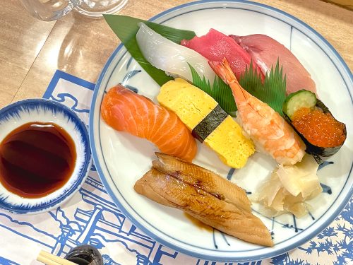 A top down view of a variety platter of sushi including shrimp, salmon and conger eel