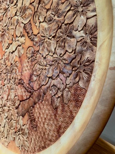 Detail shot of an ornate wooden tray with sakura flowers appearing to pop out of the wood