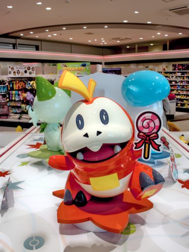 Statues of Fuecoco, Sprigatito and Quaxly on a display stand in Pokémon Center Hiroshima