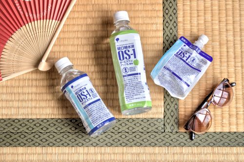PET Bottles on a tatami mat with a pair of sunglasses in one corner and a folding paper fan in the opposite corner