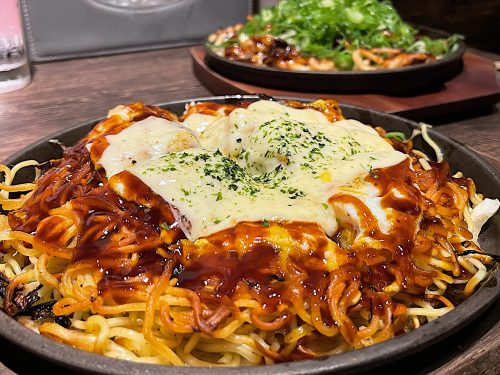 Crispy, fried noodles and sauce on a cast iron plate