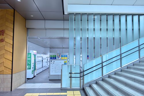 A room filled with lockers hidden next to a large staircase.