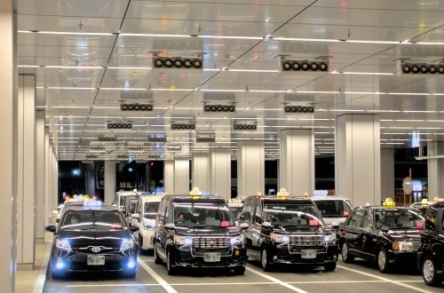 Japanese taxis wait for passengers in a train station taxi lot