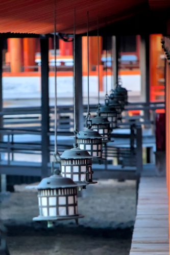 Black, rounded metal lanterns hang from metal hooks